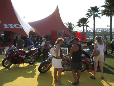 1986 Ford Bronco - An outdoor event with several motorcycles on display under a large red tent with Honda branding.