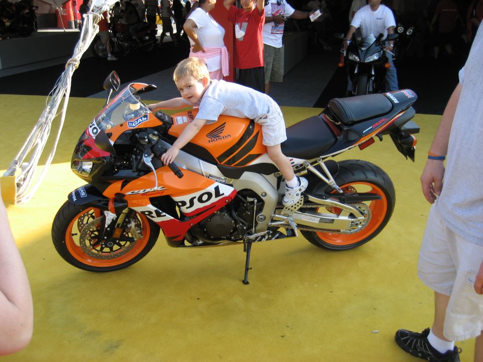 Orange and black sport motorcycle with a boy on it