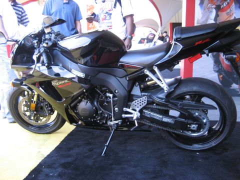1986 Ford Bronco - A black sport motorcycle is displayed on a black carpet with a yellow background.