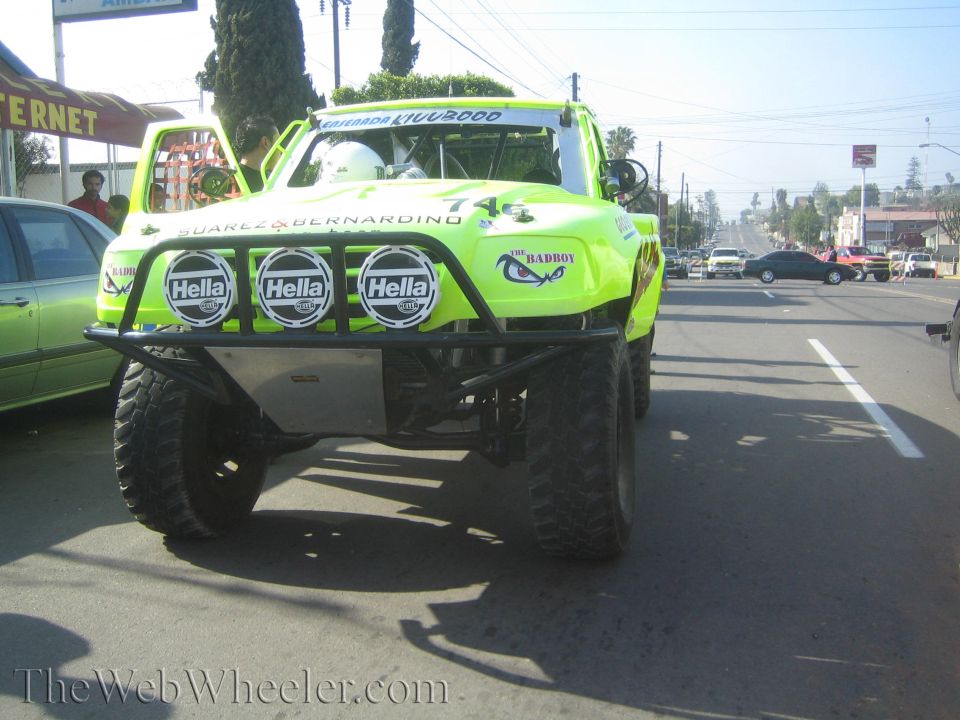 Front of bright green off-road race truck with Hella lights on road