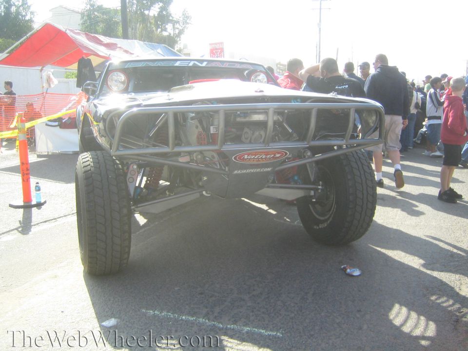 Black trophy truck with tube chassis front end in a crowd