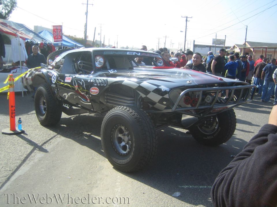 Black race truck with checkered-flag graphics on a street