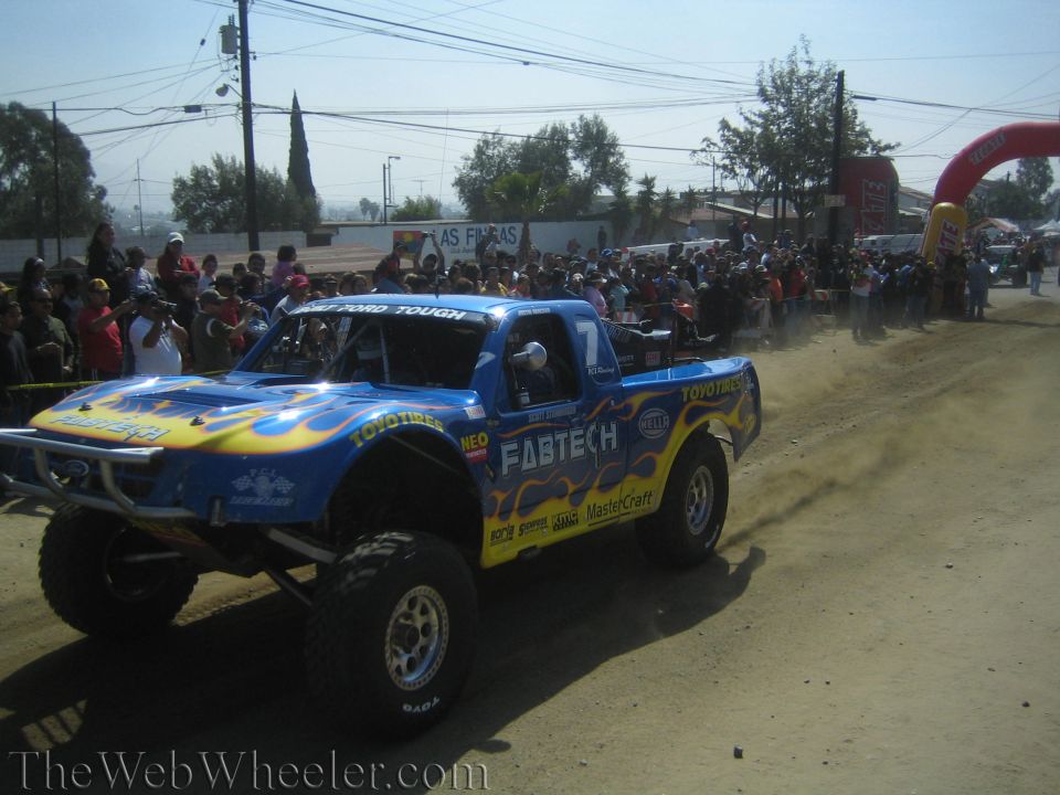 Blue flamed Fabtech Toyo Tires off-road trophy truck number 7 on dirt course