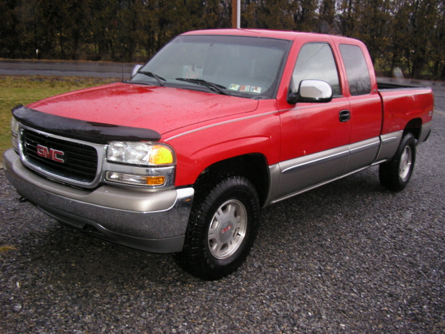 red GMC pickup truck with chrome trim and a bug deflector on the hood