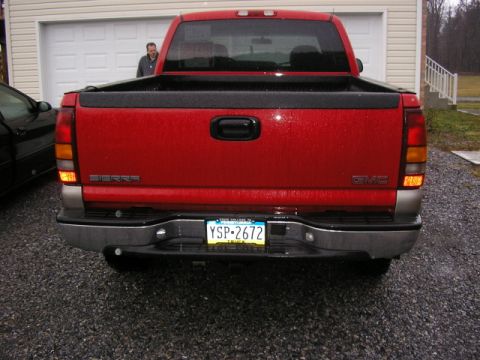 1994 Ford Probe - Rear view of a red GMC Sierra pickup truck parked in a driveway.