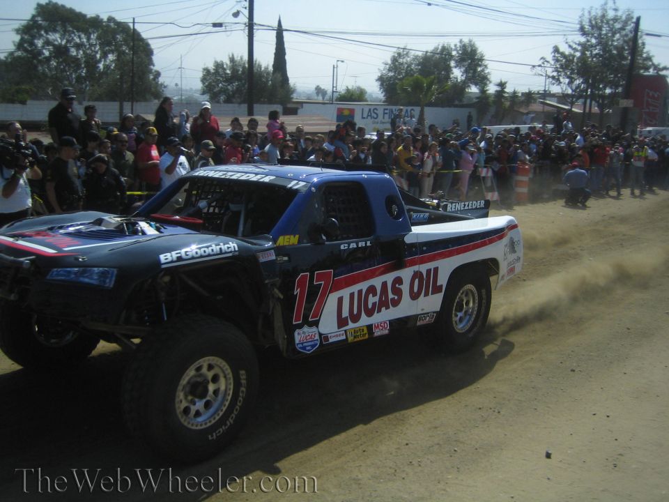 Blue and white number 17 Lucas Oil trophy truck on a dirt course