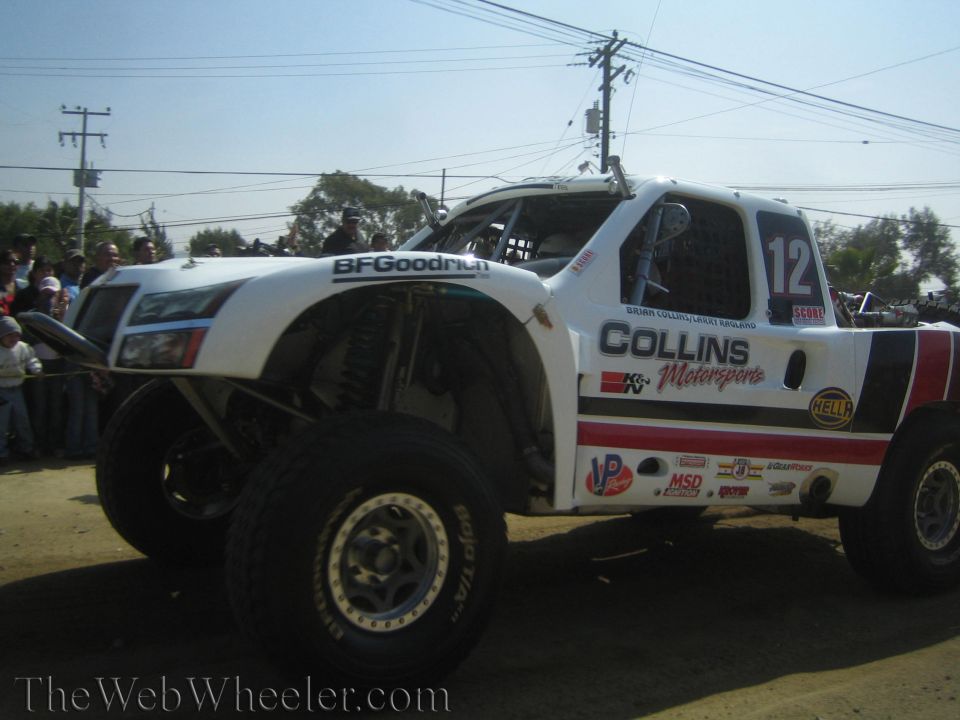 White number 12 Collins Motorsports off-road race truck on a dirt course