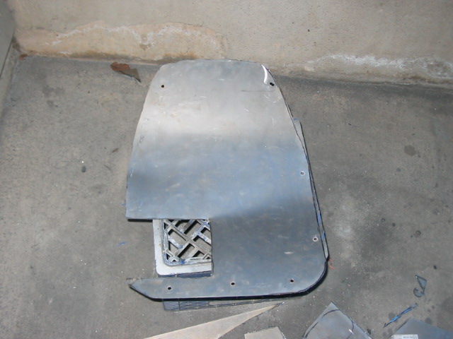 metal panel with a square vent cut out, lying on a concrete floor