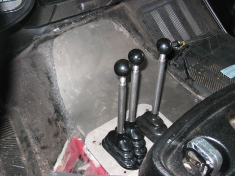 1991 Ford Bronco - The interior of a vehicle shows three manual gear shifters, suggesting a complex drivetrain setup.