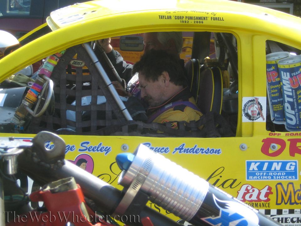 Close view into yellow race car cockpit with seated driver