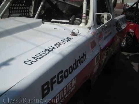 1990 Ford Bronco - Close view of a white off-road race truck's hood and fender lettered Class3Racing.com, BFGoodrich and Bilstein.