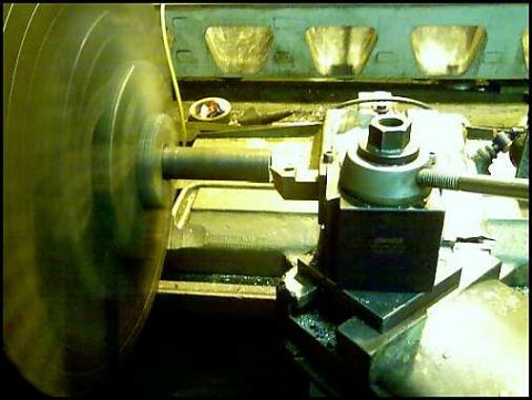 1996 Ford F-150 - A metalworking lathe is shown in operation, with a large rotating component and a tool post assembly.