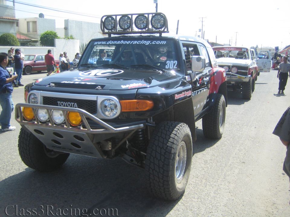 Black Toyota FJ Cruiser off-road race truck number 302 with roof lights