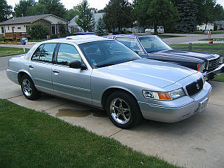 1999 Mercury Grand Marquis - Silver 1999 Mercury Grand Marquis with sunroof, parked on a paved driveway.