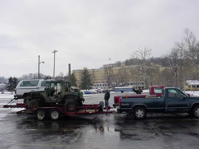 off-road vehicle on trailer being towed by a pickup truck