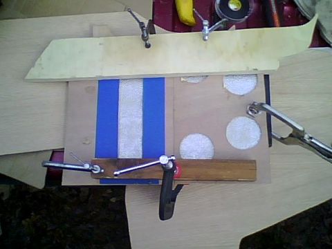 1995 Ford Bronco - A wooden console part with blue and white stripes is being worked on with clamps.