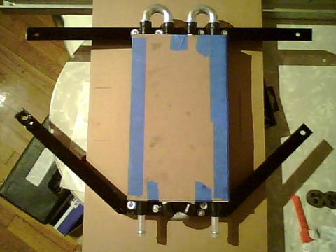 1995 Ford Bronco - Radiator and mounting hardware laid out on a cardboard surface.