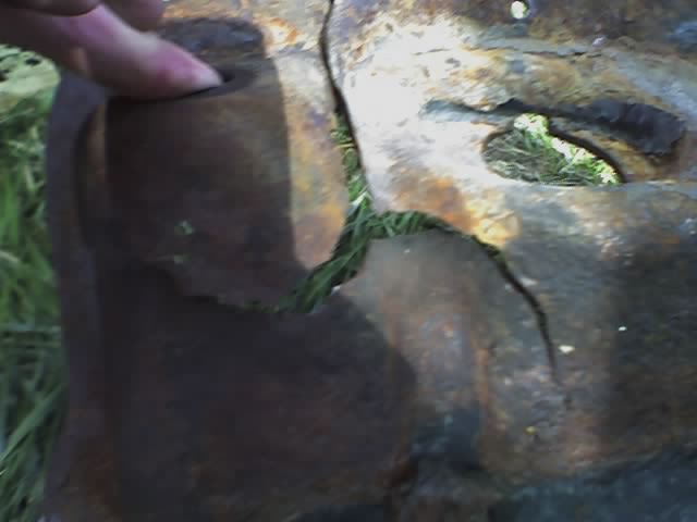 rusted metal part with a finger poking it