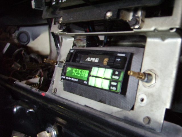 Interior view of an Alpine car stereo with a green digital display showing '92.5'