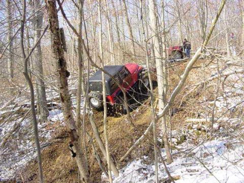 1992 Ford Bronco - Two off-road vehicles navigate a snowy, wooded incline.