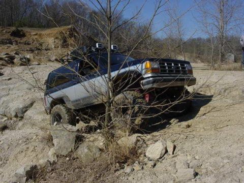 1992 Ford Bronco - This Ford Bronco is navigating a challenging off-road course with steep inclines and rocky terrain.