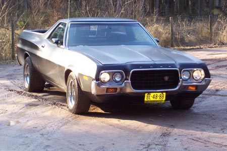 1973 Ford Ranchero - A two-tone Ford Ranchero is parked on a dirt road, with trees in the background.