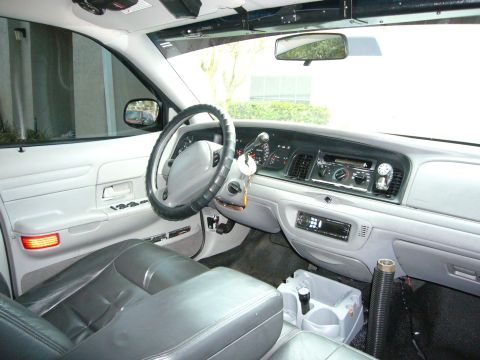 2000 Ford Crown Victoria - The interior of a 2000 Ford Crown Victoria, gray leather seats and a standard dashboard layout.
