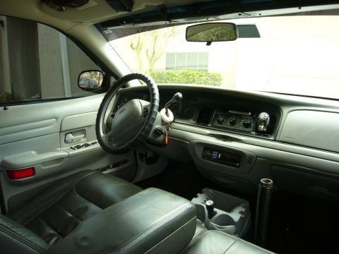 2000 Ford Crown Victoria - The interior of a 2000 Ford Crown Victoria, viewed from the passenger side, reveals the dashboard and seating area.