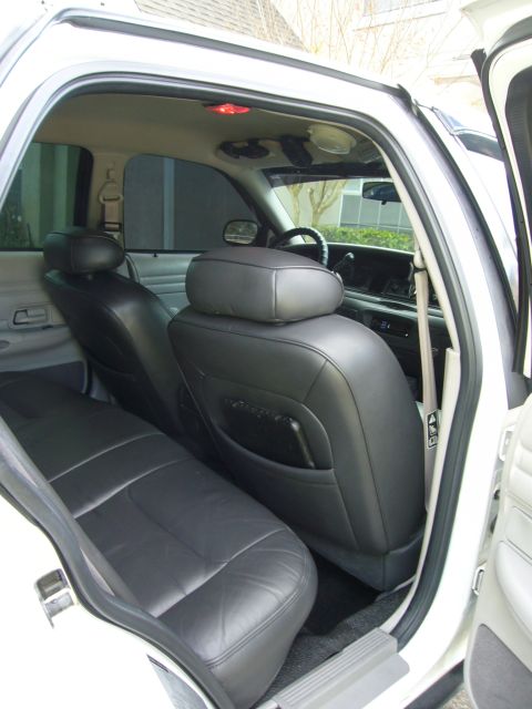 2000 Ford Crown Victoria - Rear interior view of a 2000 Ford Crown Victoria, showing the black leather seats and dashboard.