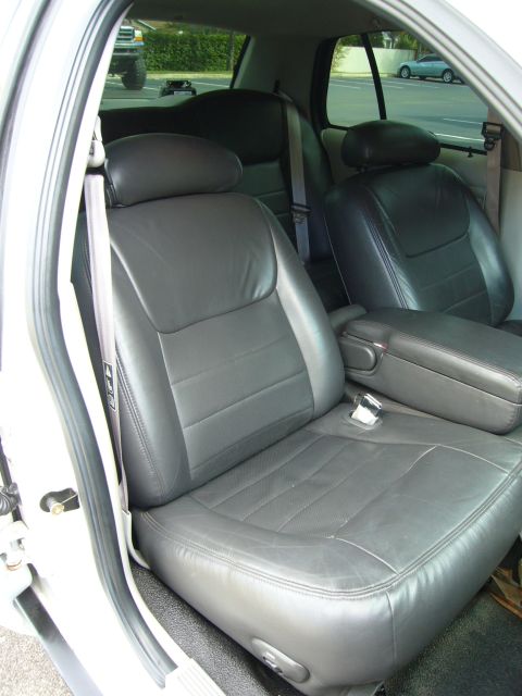 2000 Ford Crown Victoria - View of the leather seats and center console inside a vehicle, with another car seen outside.