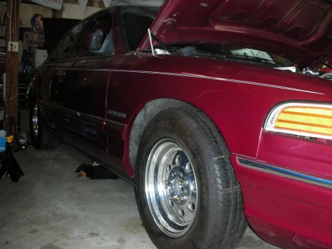 1992 Ford Crown Victoria - This 1992 Ford Crown Victoria is in a garage with its hood up, revealing custom wheels and a maroon exterior.