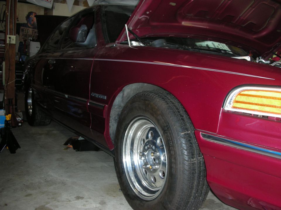 Maroon 1992 Ford Crown Victoria with hood open, showing custom wheels