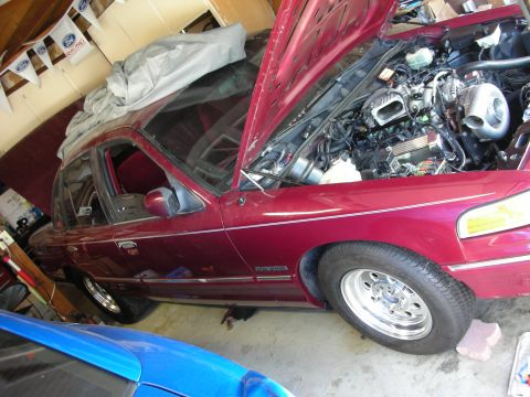 1992 Ford Crown Victoria - The engine bay of a 1992 Ford Crown Victoria is exposed, revealing a turbocharger and other modifications.
