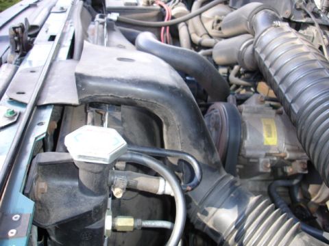 1996 Ford Bronco - Close-up of the engine bay, focusing on the radiator and air intake system components.