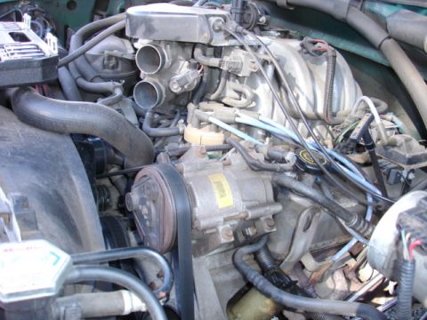 1996 Ford Bronco - Close-up view of a vehicle's engine bay, showing various mechanical parts and wiring.