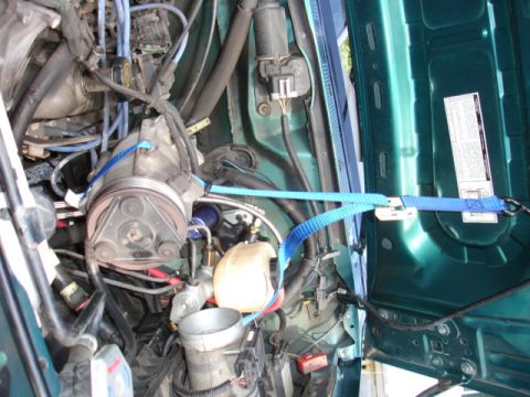 1996 Ford Bronco - The engine bay of a 1996 Ford Bronco, showing the air conditioning compressor and various hoses.
