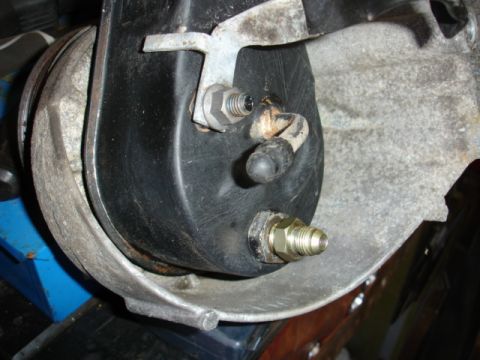 1996 Ford Bronco - Close-up view of a brake booster assembly, highlighting its components and a brass fitting.