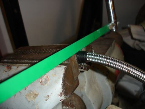 1996 Ford Bronco - Cutting a braided hose with a hacksaw blade held in a vise.