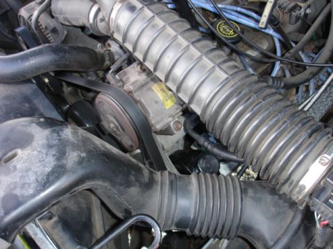 1996 Ford Bronco - Close-up view of engine components, including the air intake system and serpentine belt.