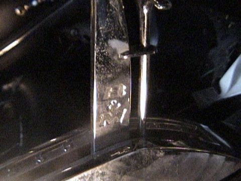 1977 Ford Mustang - Close-up of a chrome shifter lever showing stamped part numbers.