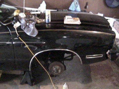 1977 Ford Mustang - Front fender and wheel well of a 1977 Ford Mustang II, undergoing maintenance.