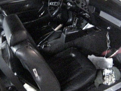 1977 Ford Mustang - The interior of a 1977 Ford Mustang features black vinyl seats and a dashboard with visible gauges.