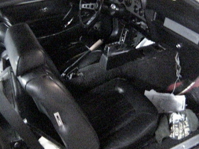 Interior of a 1977 Ford Mustang showing black seats and dashboard