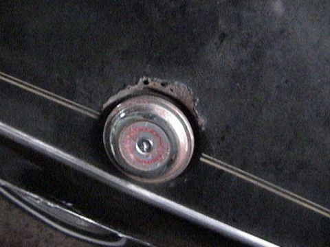 1977 Ford Mustang - A close-up view of a car's emblem, showing some wear and tear around the mounting point.