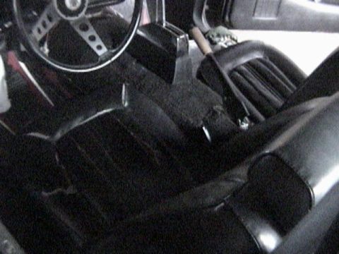 1977 Ford Mustang - The interior of a 1977 Ford Mustang, black seats and a distinctive steering wheel.