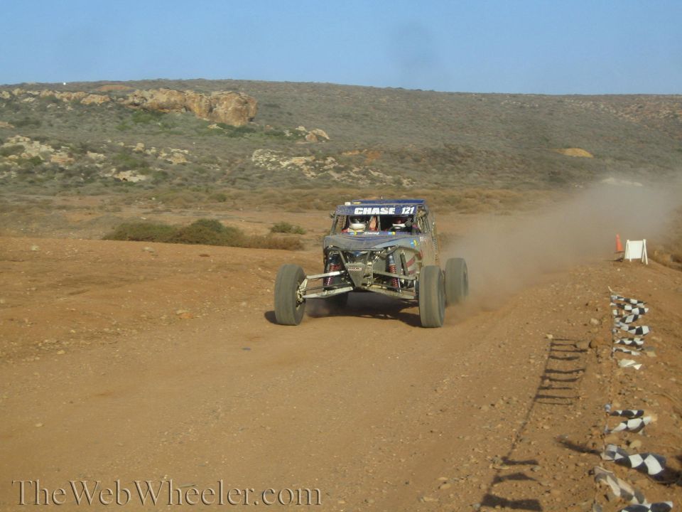 Blue Chase 121 off-road buggy racing on a checkered-flag desert track