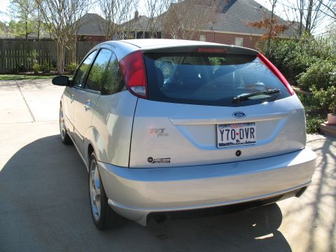 1993 Ford Bronco - Silver 2003 SVT Focus hatchback with Texas plates Y70-DVR is parked on a concrete driveway.