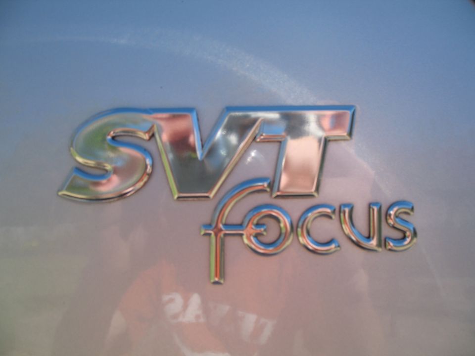 Chrome SVT Focus badge on a light-colored car