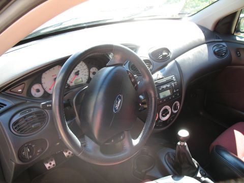 1993 Ford Bronco - The interior of a Ford Focus shows the dashboard, steering wheel, and gear shifter.