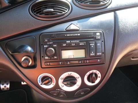 1993 Ford Bronco - The center console of a car features an audio system and climate control knobs.